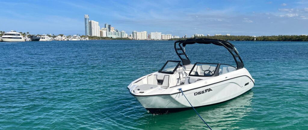 A private boat charter Miami with captain cruising through Biscayne Bay with a view of the downtown skyline.